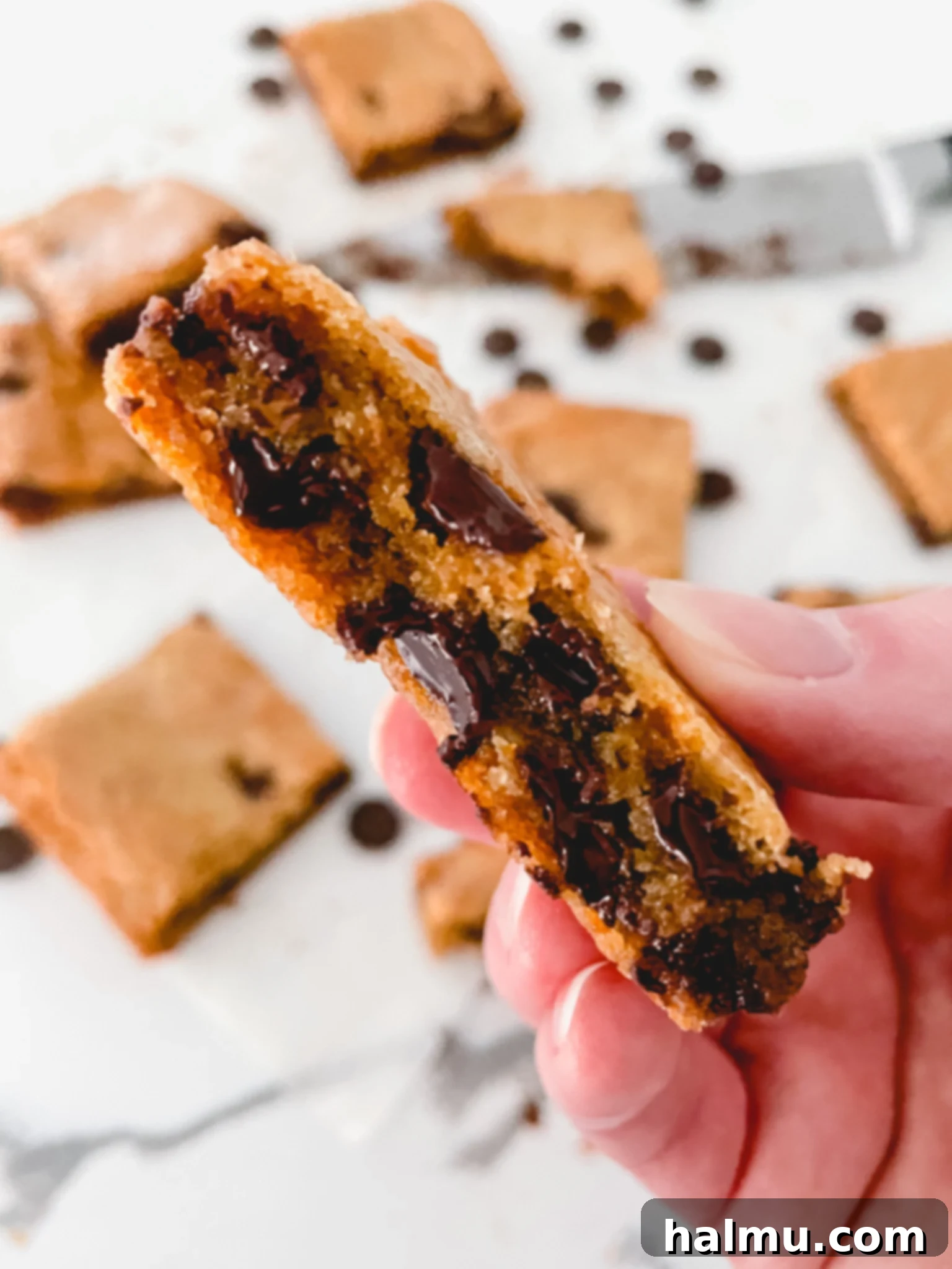 Close-up of a stack of golden-brown blondie bars with melted chocolate chips, highlighting their chewy texture.