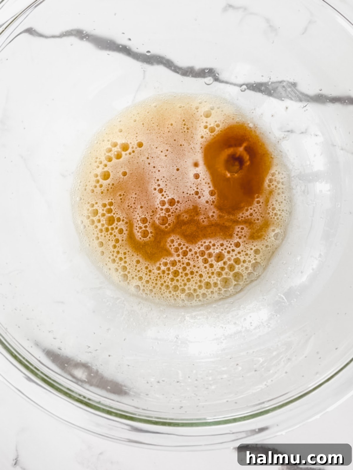 Close-up of golden brown butter simmering in a saucepan, showing the separation of milk solids.