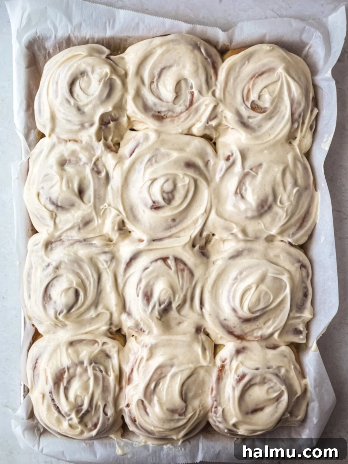 Golden Brown Butter Brioche Cinnamon Swirls 4 Freshly baked brown butter brioche cinnamon rolls cooling in a baking dish, with golden-brown tops and visible cinnamon swirls.