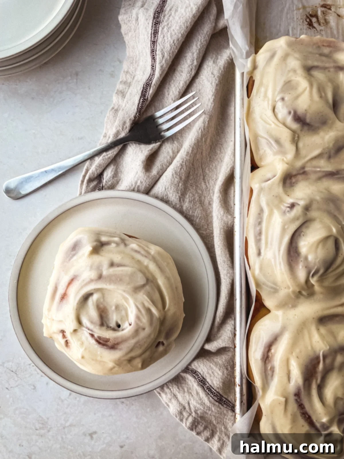 Golden Brown Butter Brioche Cinnamon Swirls 8 A wider shot of the brown butter brioche cinnamon rolls in a baking dish, showcasing their golden color and ample frosting.