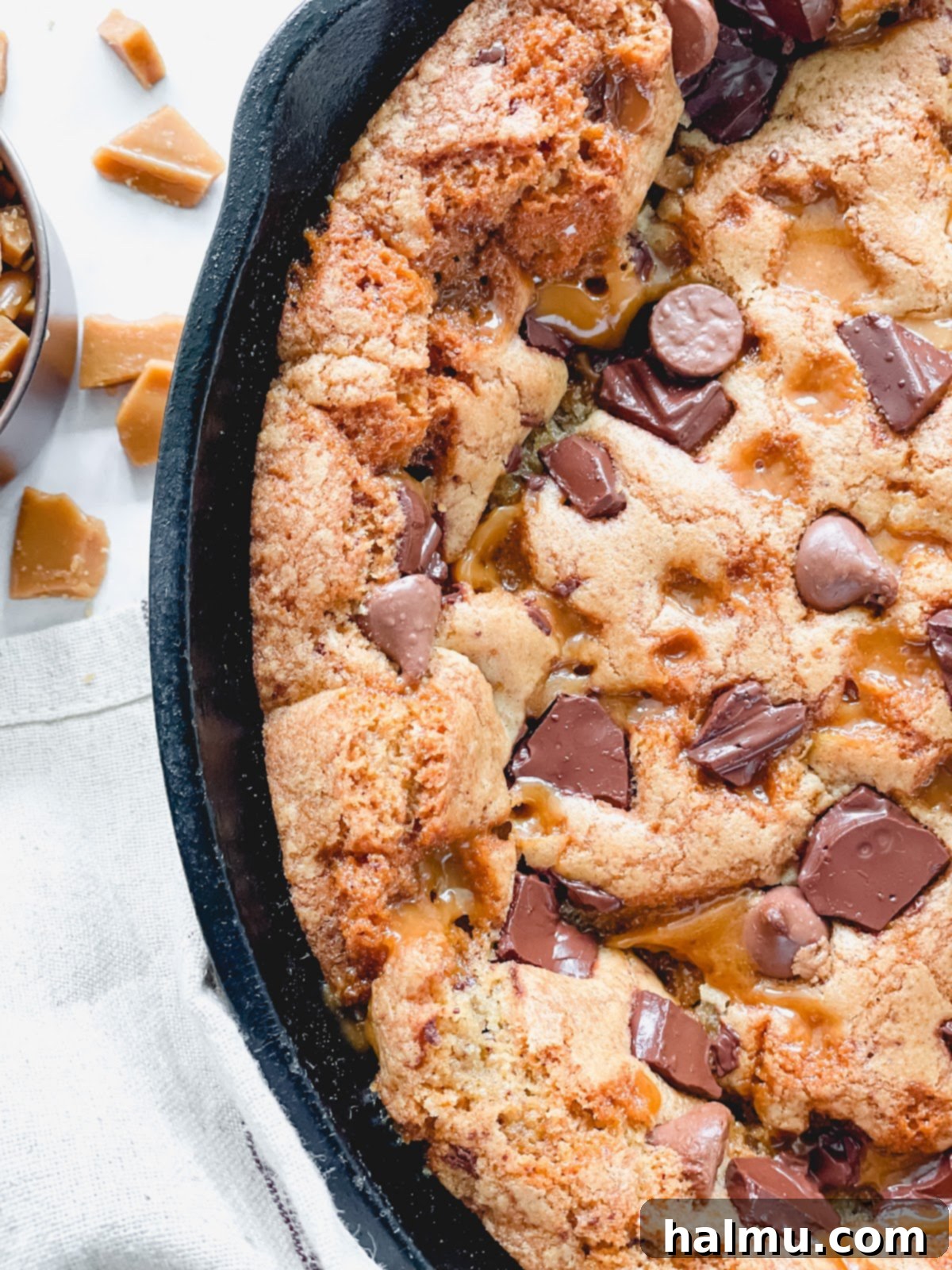 Gooey Brown Butter Toffee Skillet Cookie 4 A close-up shot of homemade toffee pieces on parchment paper, showcasing their irregular shapes.