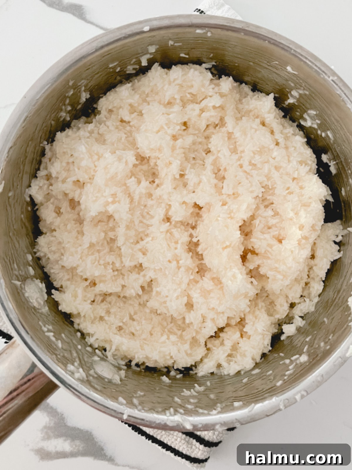 Shredded coconut being stirred into the egg white mixture