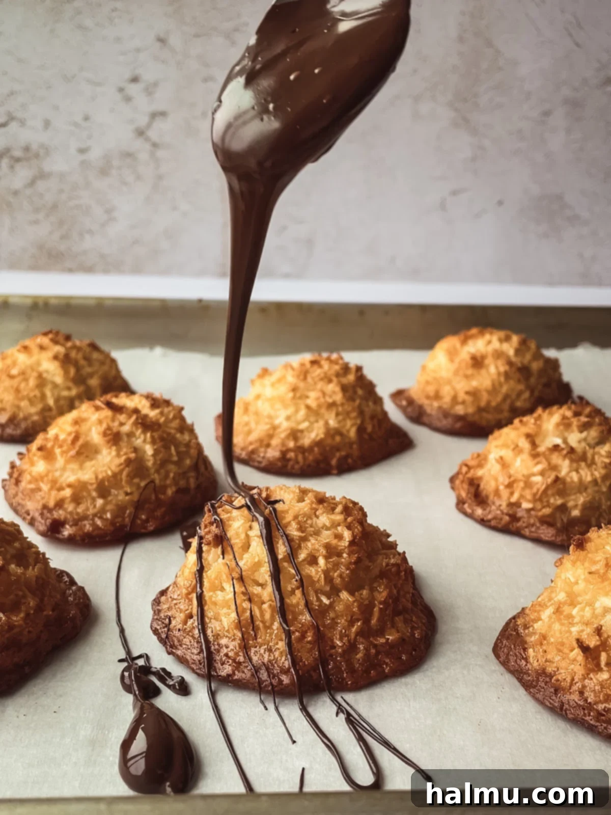 Coconut macaroons with chocolate drizzle stacked on a plate