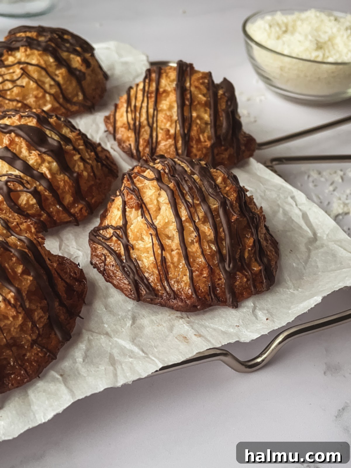 A plate of coconut macaroons with melted chocolate drizzle