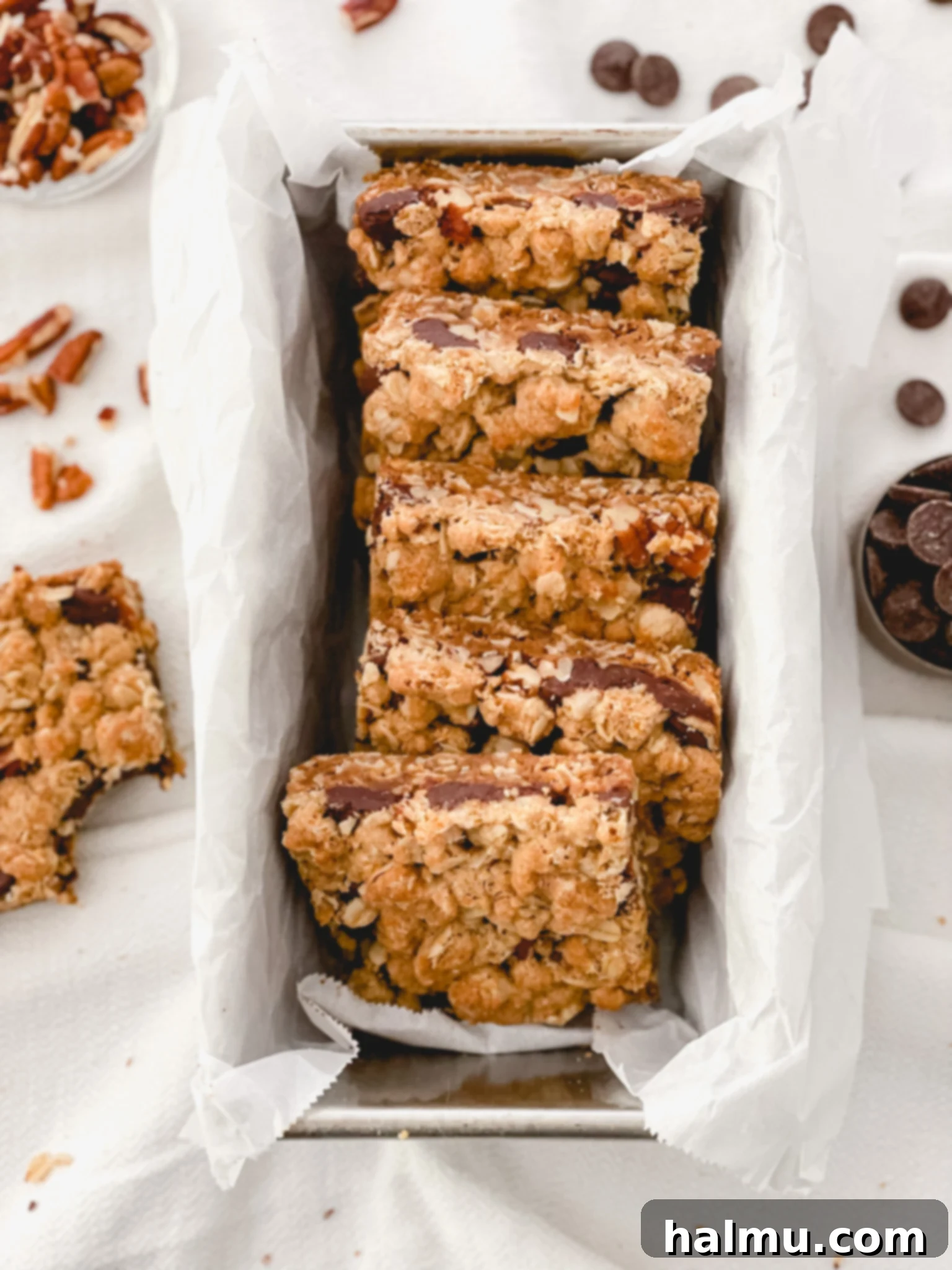 Close-up of freshly baked Chocolate Caramel Pecan Bars, showing the gooey caramel and crunchy pecan topping over a golden oat base.