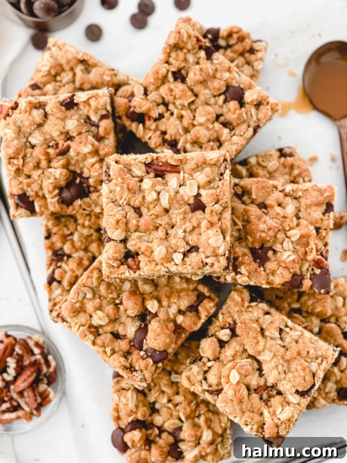 A close-up of the finished Chocolate Caramel Pecan Bars, stacked, with a slightly melted chocolate drizzle, ready for serving.