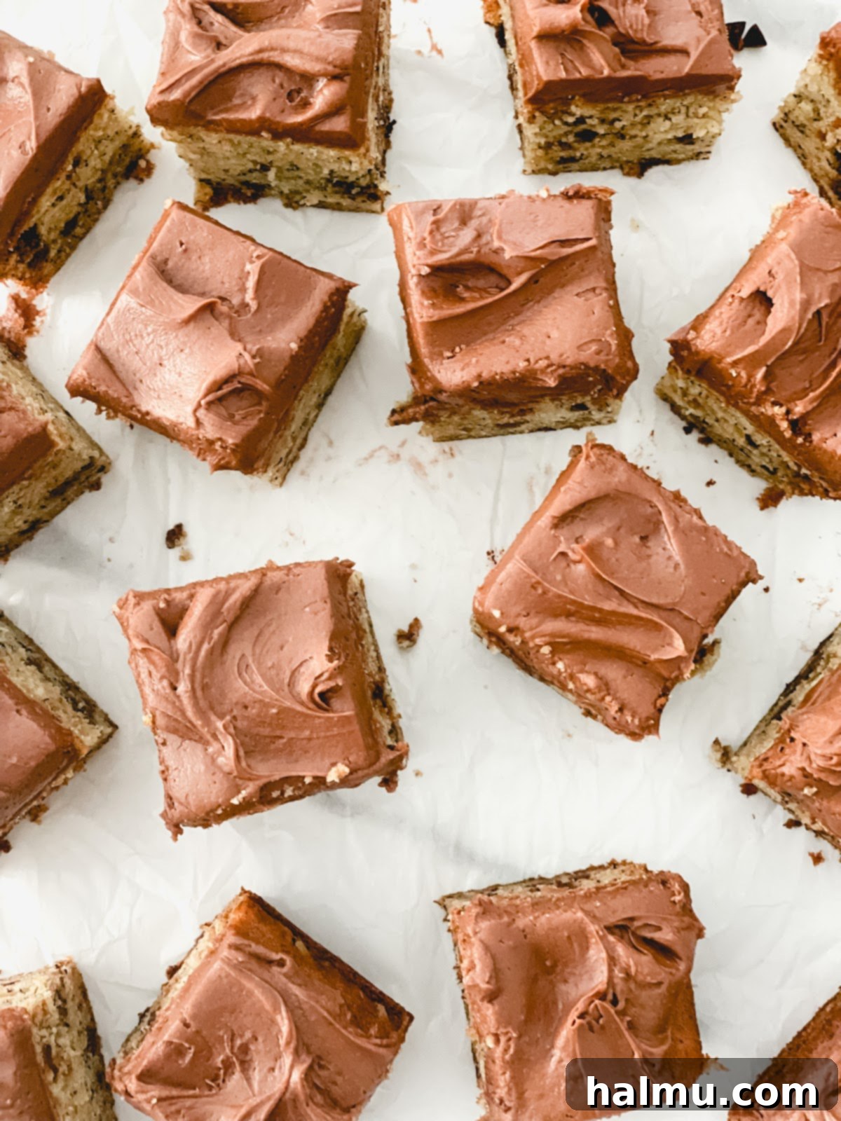 Overhead shot of an 8x8 inch square chocolate chip banana cake, frosted with a thick layer of chocolate cream cheese frosting