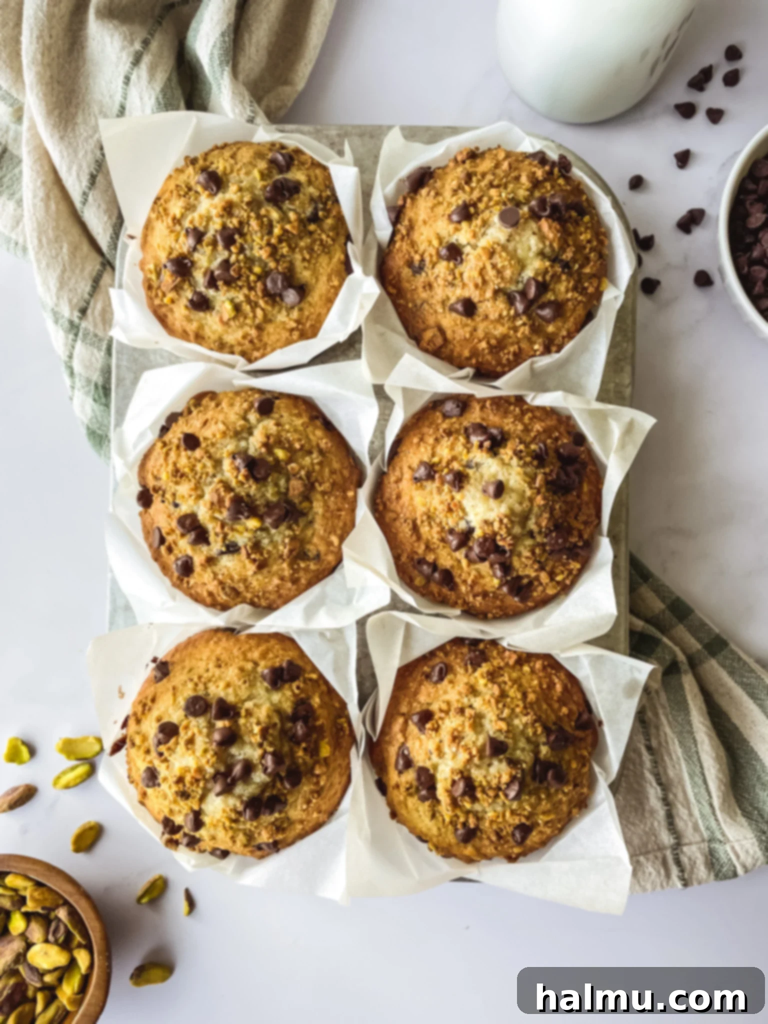 Freshly baked Chocolate Chip Pistachio Muffins cooling on a wire rack.