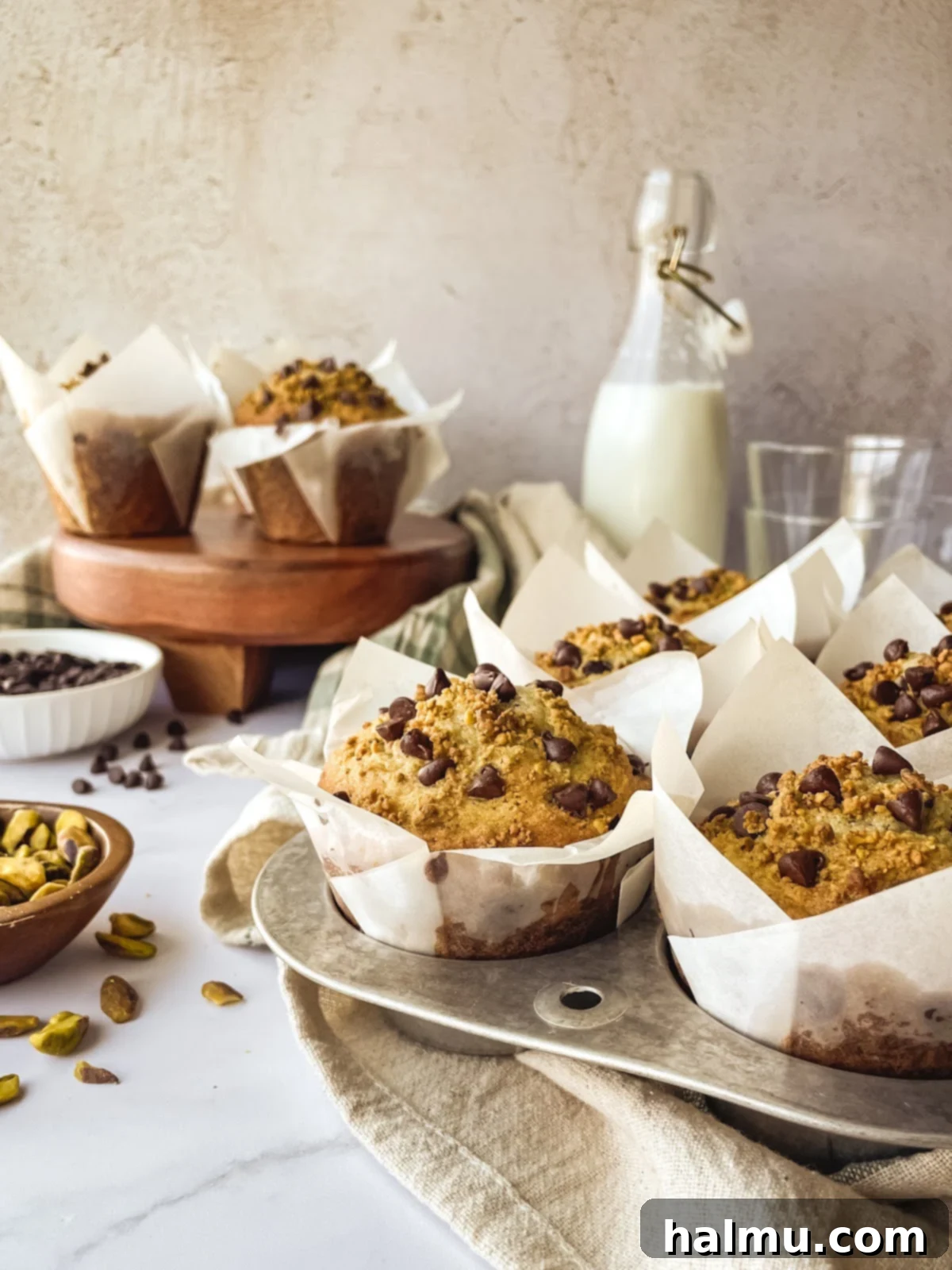 Muffin batter with pistachios and chocolate chips being mixed in a bowl.