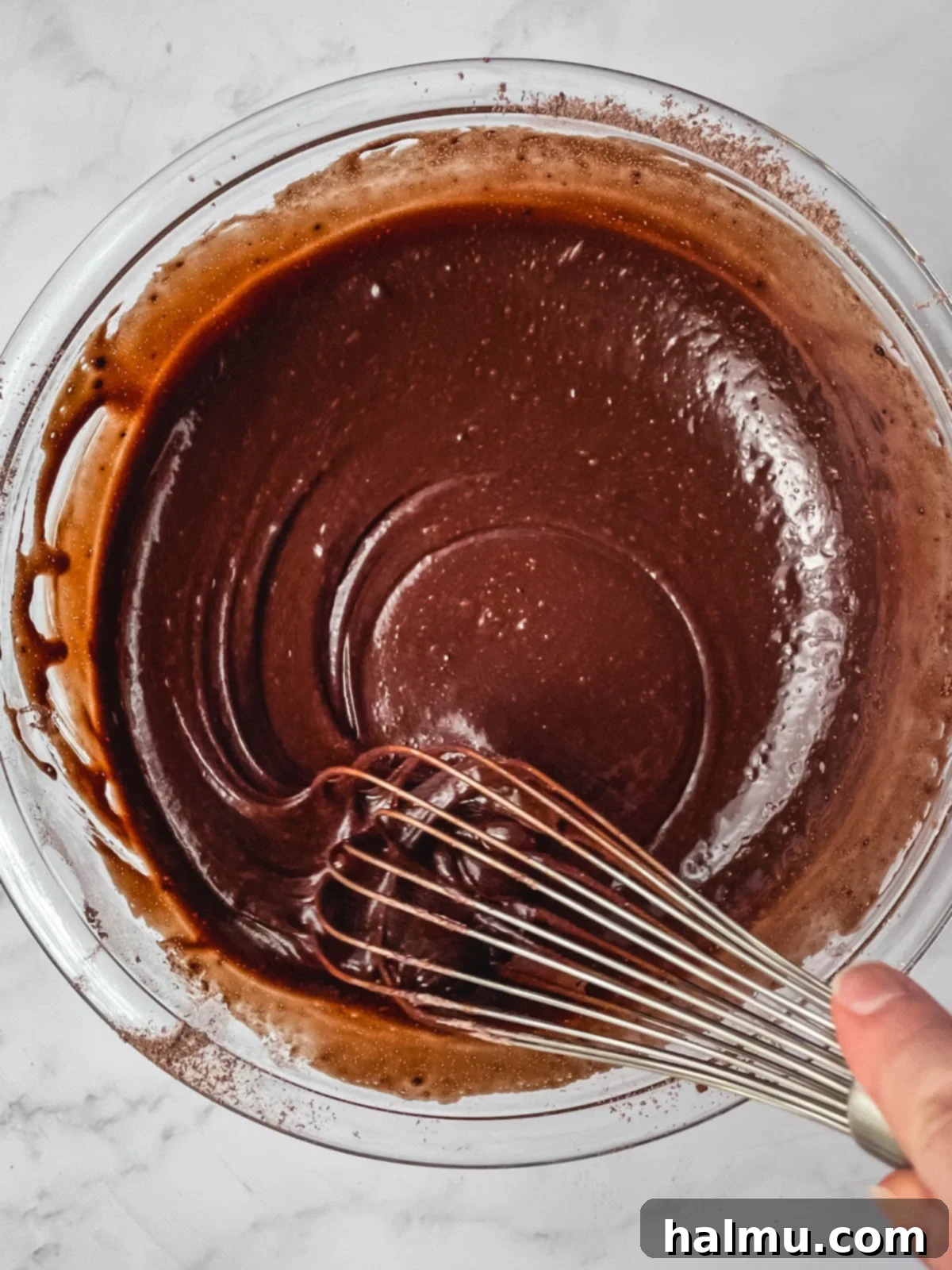 Freshly baked chocolate cake with holes already poked, steam gently rising, ready for the pudding.