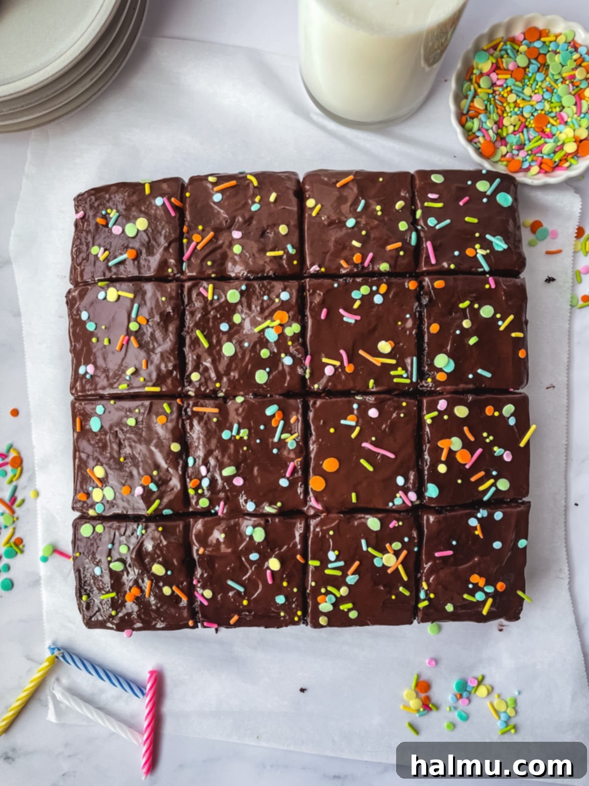 A slice of chocolate pudding poke cake revealing layers of moist cake and creamy pudding, garnished with sprinkles.
