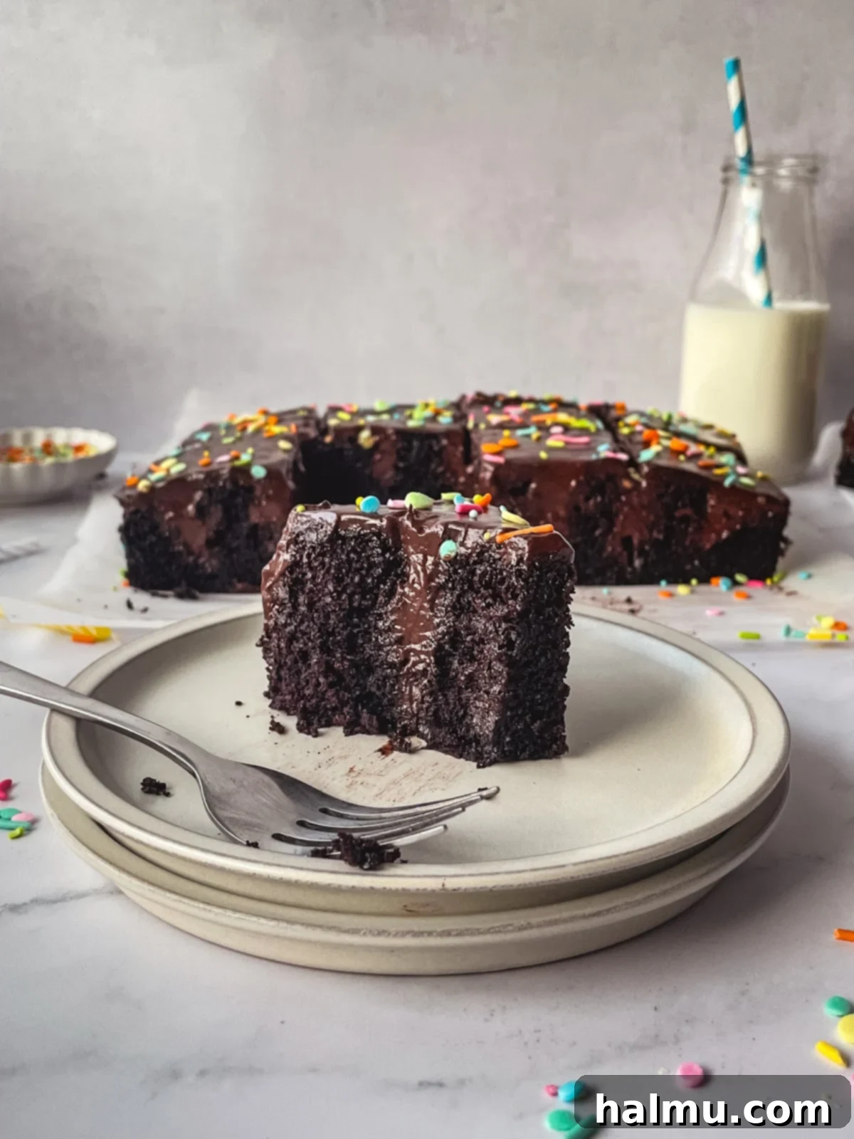 A decadent slice of chocolate pudding poke cake, perfect for a special occasion.