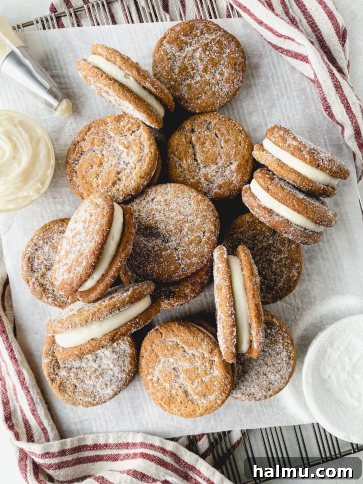 Ginger Molasses Sandwich Cookies 3 A close-up of a single ginger molasses cookie sandwich, showing the thick layer of cream cheese frosting and the sugared edges of the cookies.