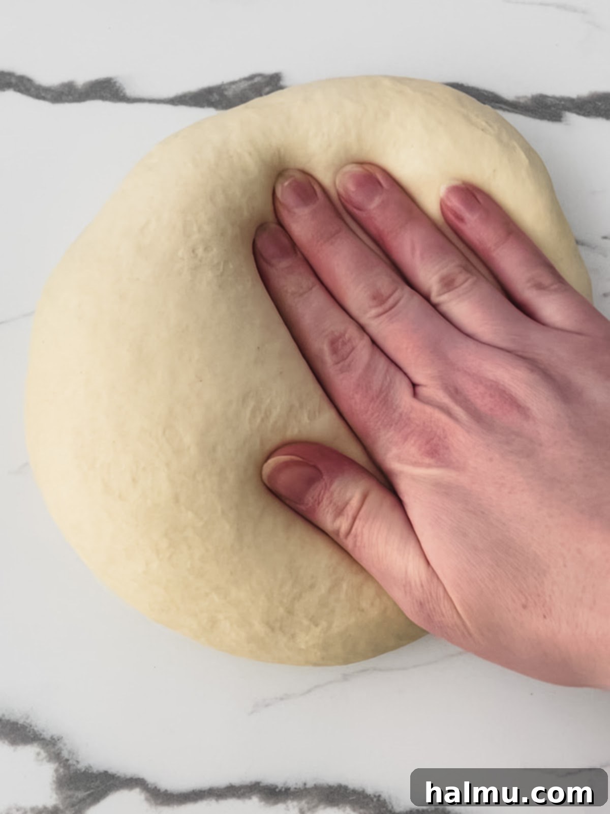 Dough rounds sprinkled with cornmeal on a baking sheet