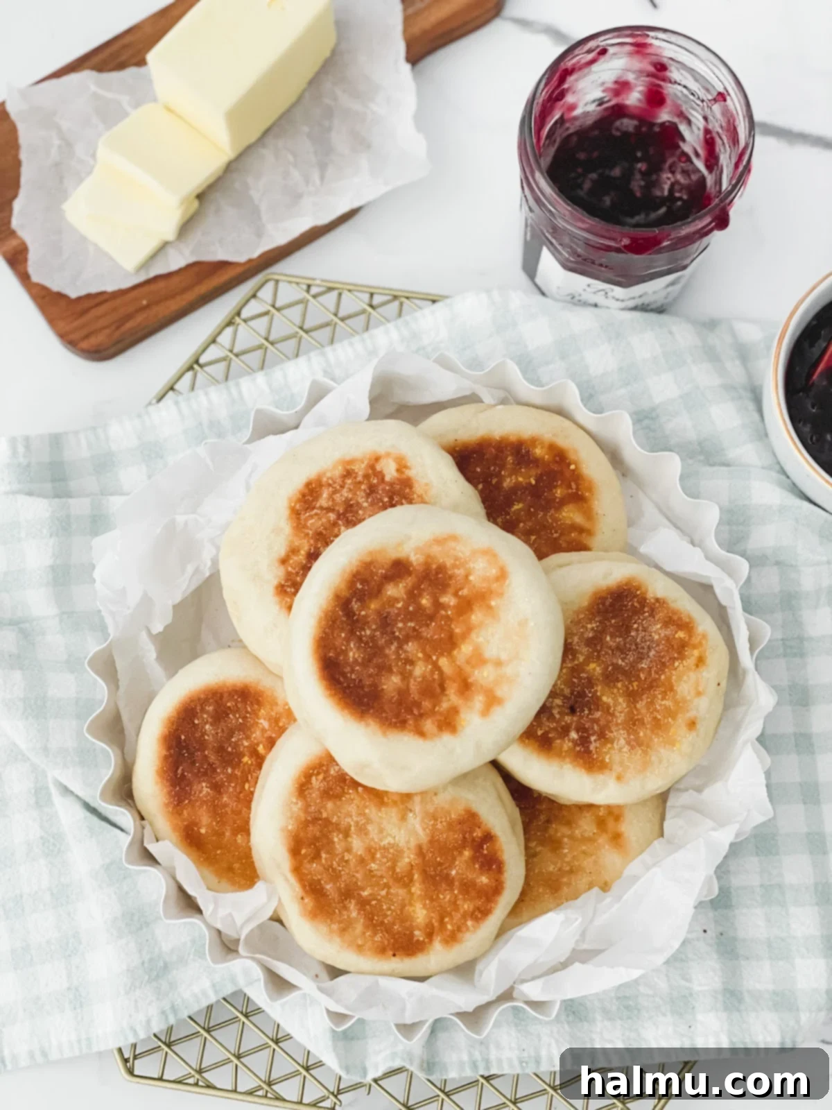 A toasted English muffin with various toppings like butter, jam, and avocado
