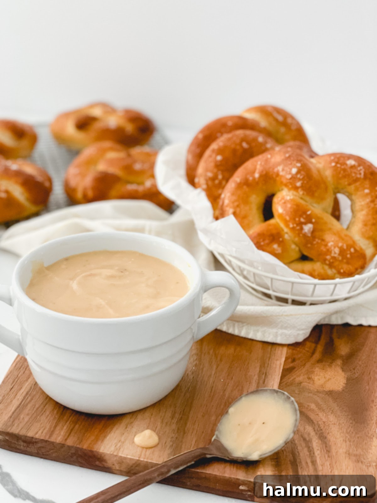 An assortment of homemade soft pretzels displayed with a variety of dipping sauces, including cheese, mustard, and sweet options.