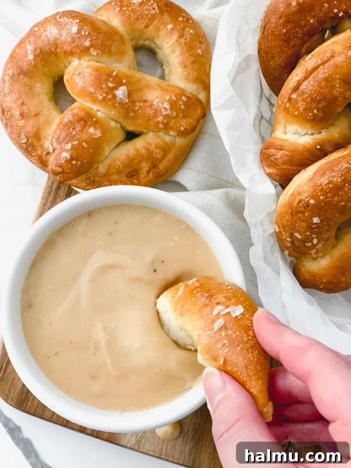 A table filled with an array of homemade soft pretzels and various dips, ready for a gathering or party.