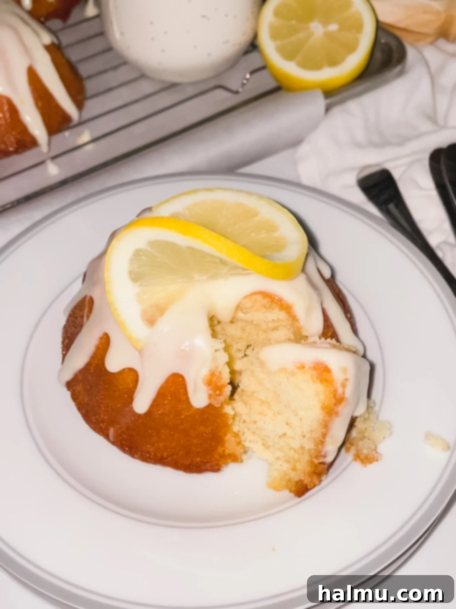 Close-up of a mini lemon bundt cake with a creamy glaze and lemon zest