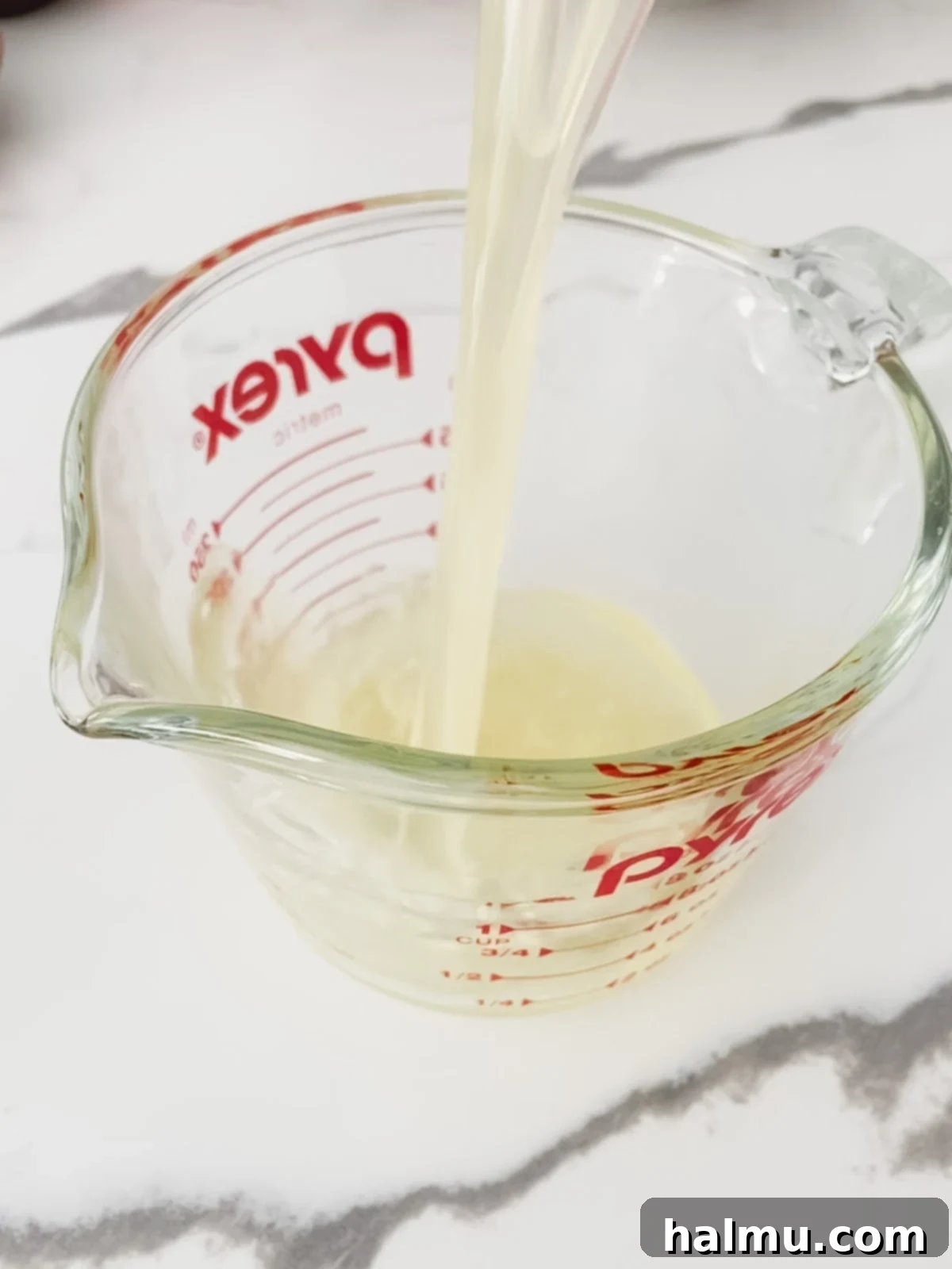 Close-up of a mini lemon bundt cake being soaked in lemon syrup