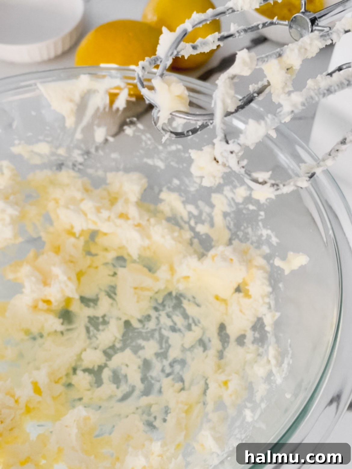 Mini lemon bundt cakes being drizzled with cream cheese glaze