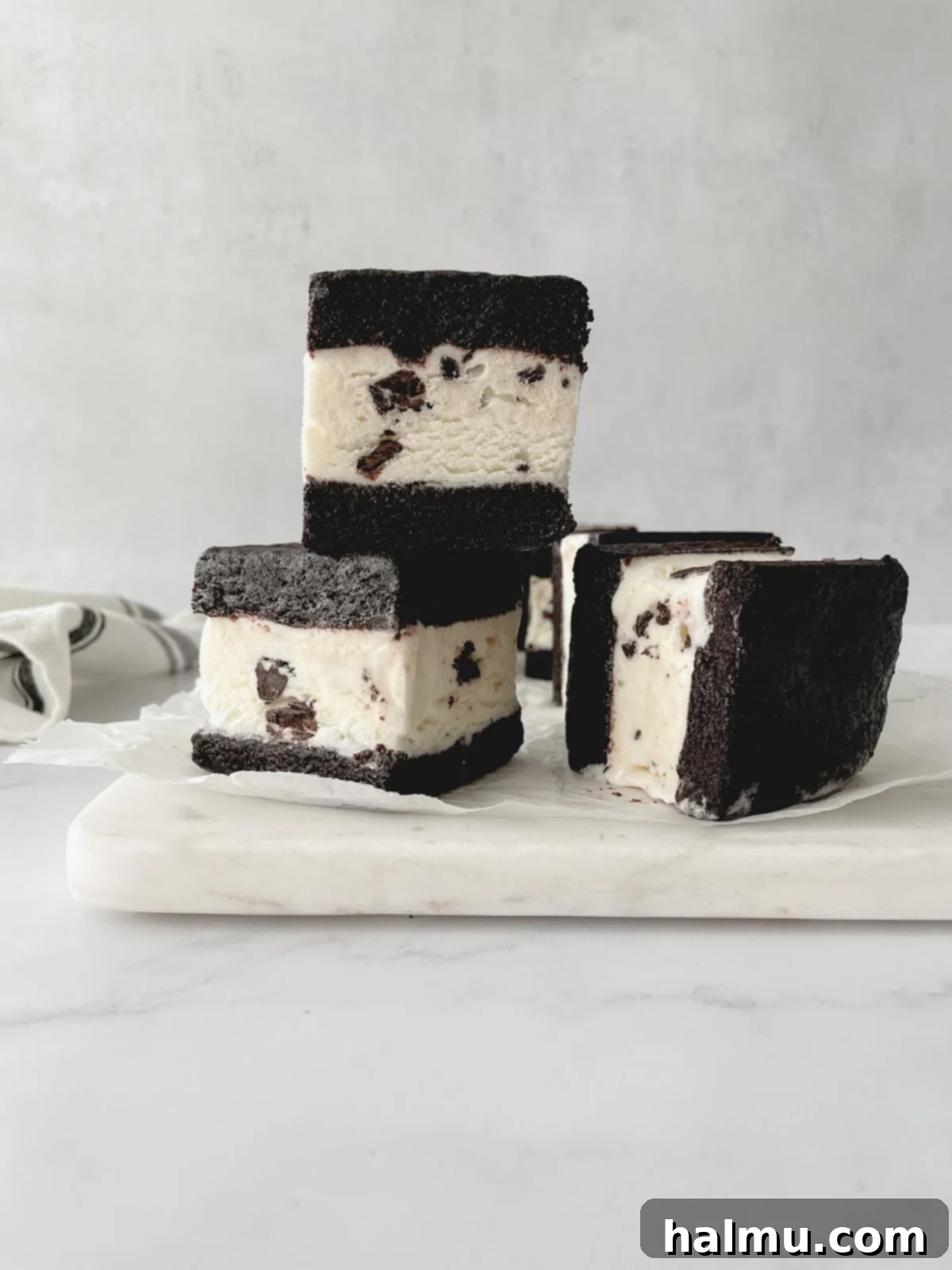 Refreshing Mint Chocolate Chip Ice Cream Delights 6 A stack of three homemade Mint Chocolate Chip Brownie Ice Cream Sandwiches, garnished with a few loose chocolate chips.