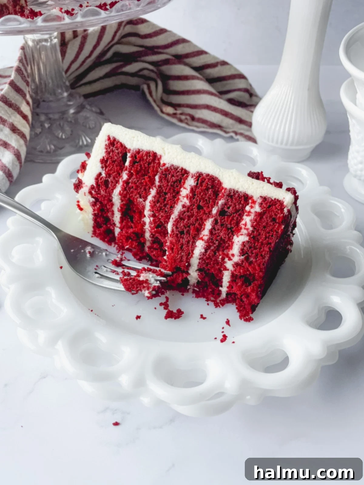 Heirloom Red Velvet Cake 7 Red velvet cake with old fashioned frosting on a cake stand, decorated with crumbs and rosettes.