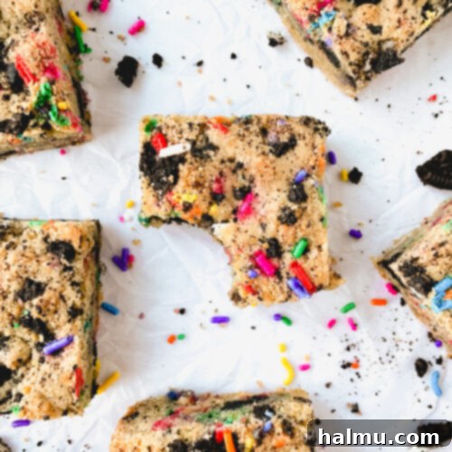 Party Oreo Funfetti Blondies 8 Close-up of a stack of three Oreo Funfetti Blondies, showcasing the chewy texture and colorful mix of Oreos and sprinkles.
