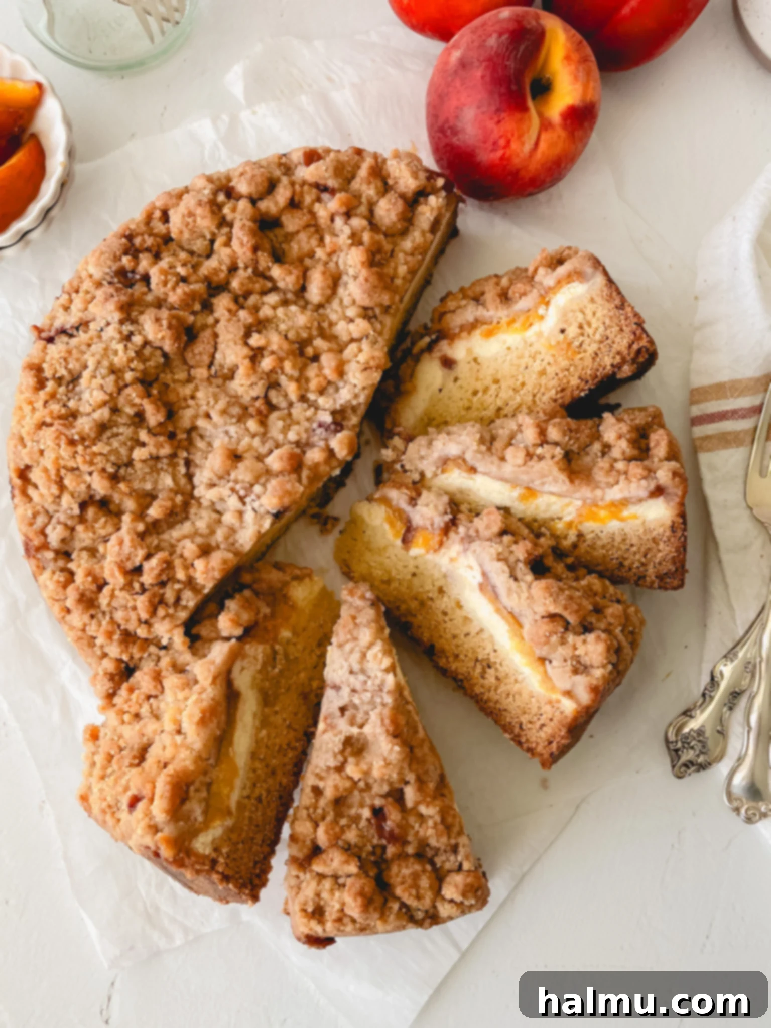 Heavenly Peach and Cream Crumb Cake 2 A vibrant Peaches & Cream Crumb Cake, showcasing its luscious layers and crumbly topping, ready to be served on a rustic wooden surface.