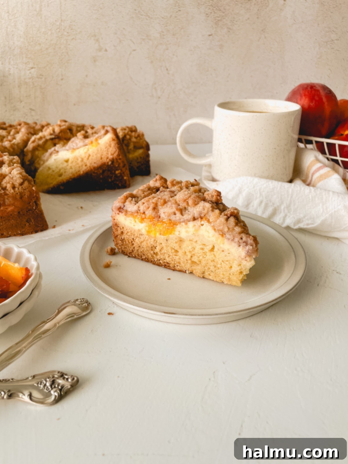 Heavenly Peach and Cream Crumb Cake 7 Another view of a whole Peaches & Cream Crumb Cake, showcasing its golden crumb top and the rich color of the peaches.