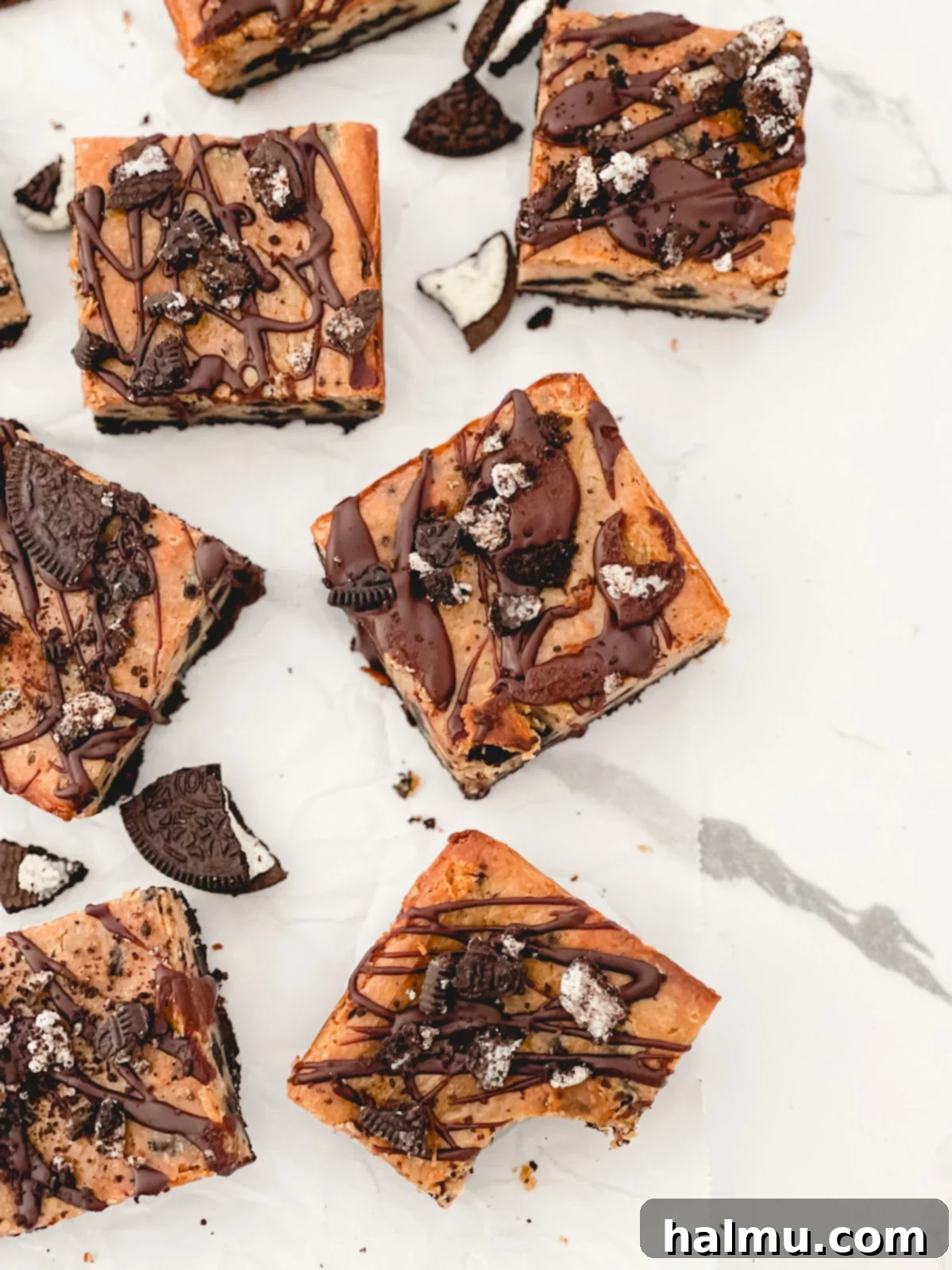 Close-up of a single Peanut Butter Oreo Cheesecake Bar showing its distinct layers of crust, filling, and ganache.