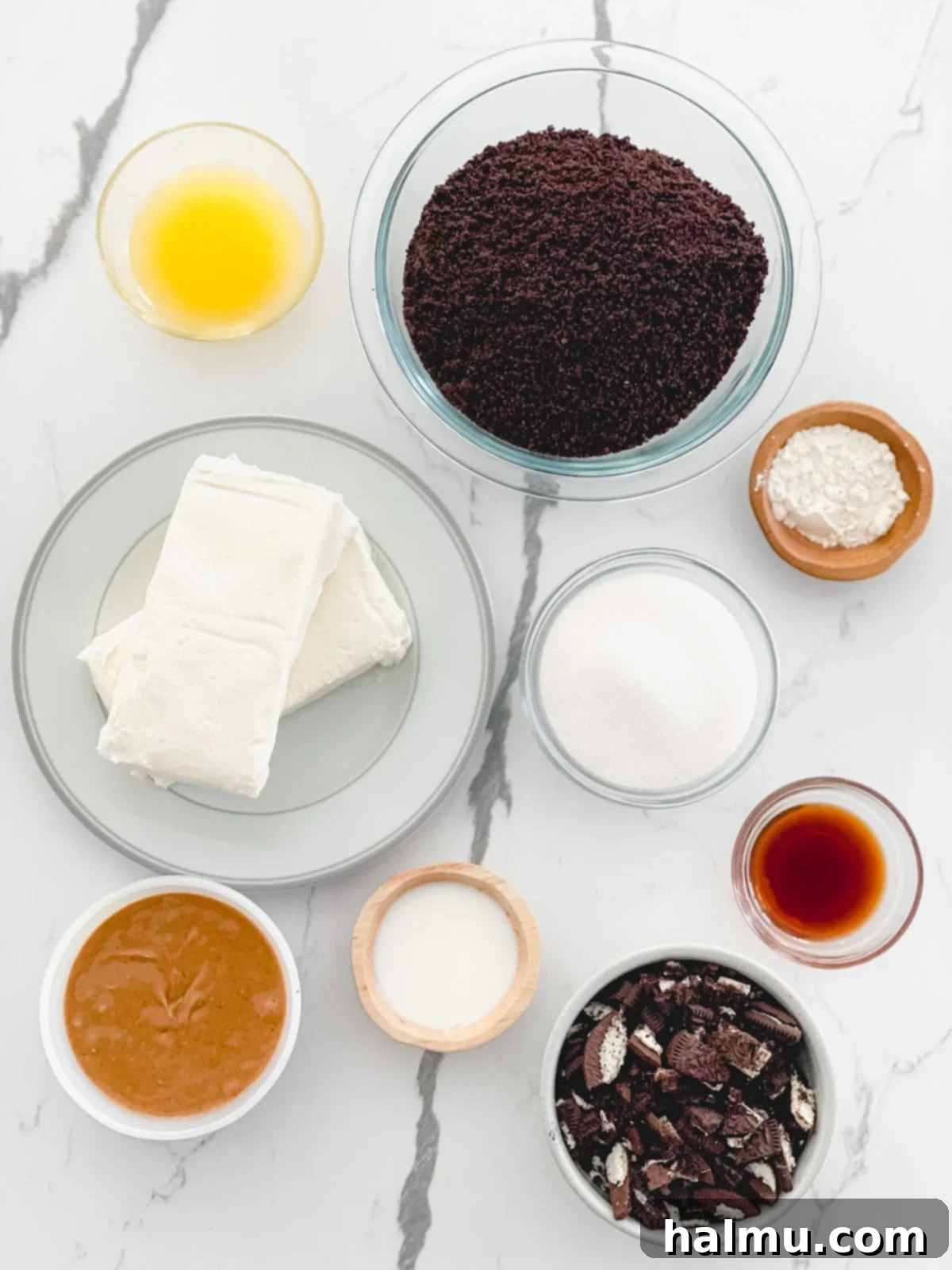 All the raw ingredients for Peanut Butter Oreo Cheesecake Bars neatly laid out on a table.