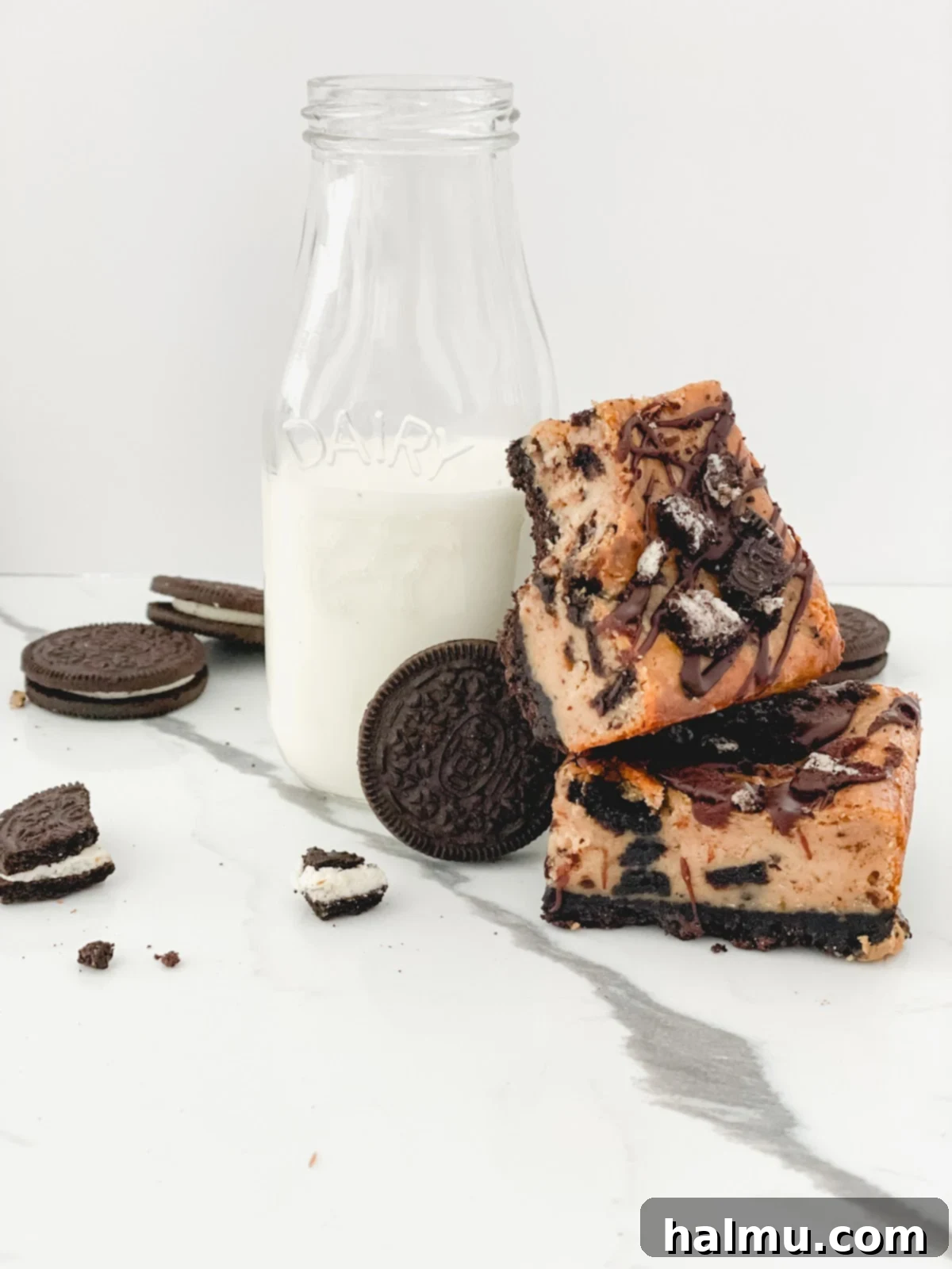 A beautifully presented slice of Peanut Butter Oreo Cheesecake Bar with ganache drizzle and crushed Oreos.
