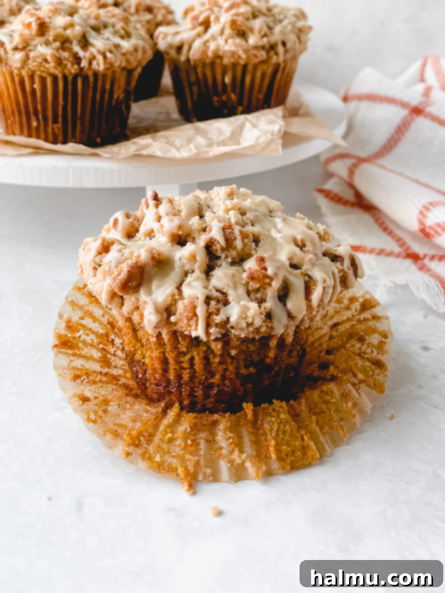 Harvest Pumpkin Cinnamon Crumble Muffins 2 Freshly baked Pumpkin Cinnamon Streusel Muffins with a drizzle of maple glaze, perfect for fall.