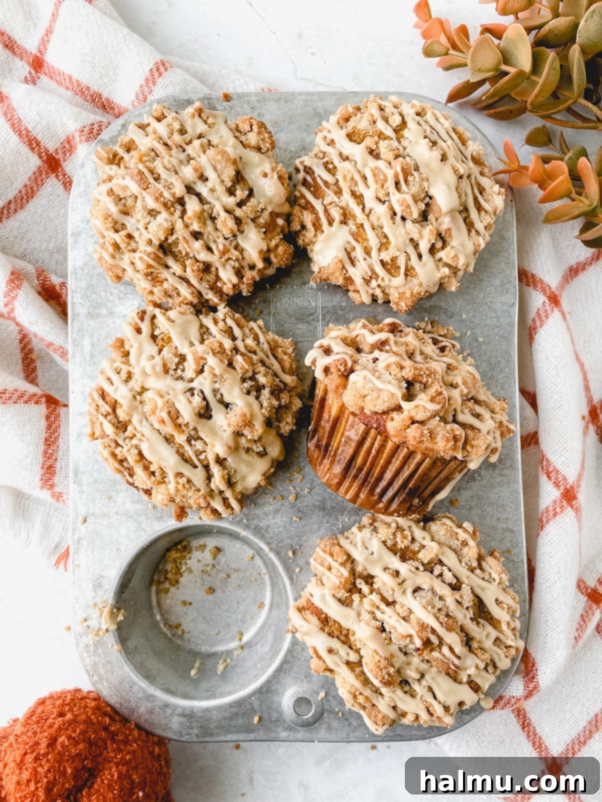 Harvest Pumpkin Cinnamon Crumble Muffins 3 Close-up of a Pumpkin Cinnamon Streusel Muffin, showing its fluffy texture, cinnamon swirl, and crumbly streusel topping.