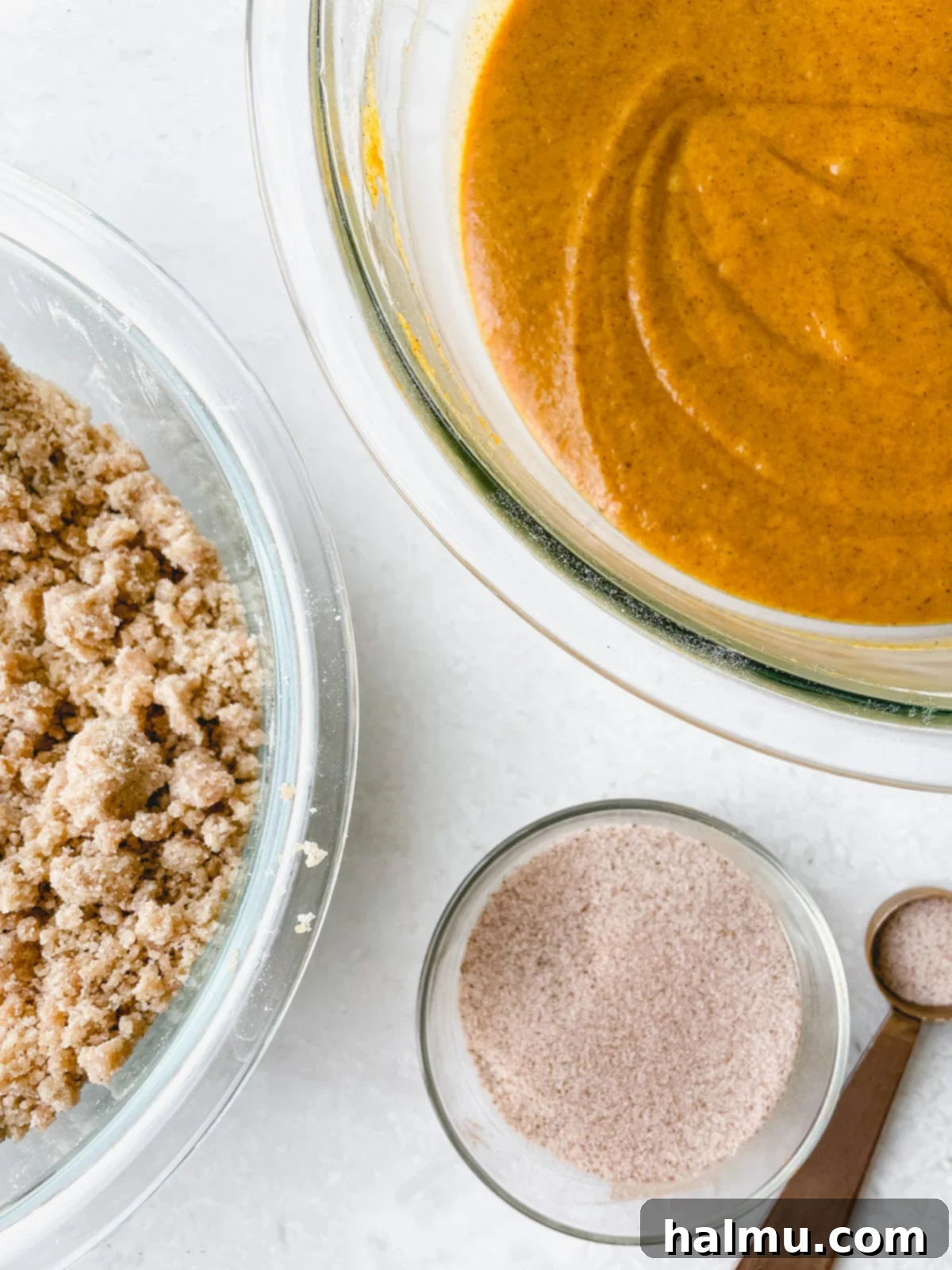 Harvest Pumpkin Cinnamon Crumble Muffins 6 Close-up of a muffin tin being filled with layers of pumpkin batter and cinnamon sugar.