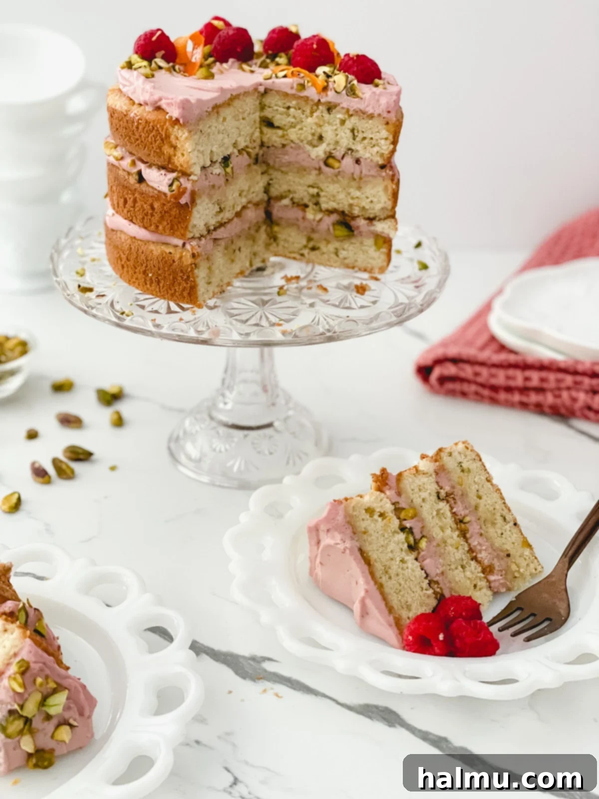 Close-up of a Raspberry Orange Pistachio Cake slice, showing the moist cake layers and vibrant filling.