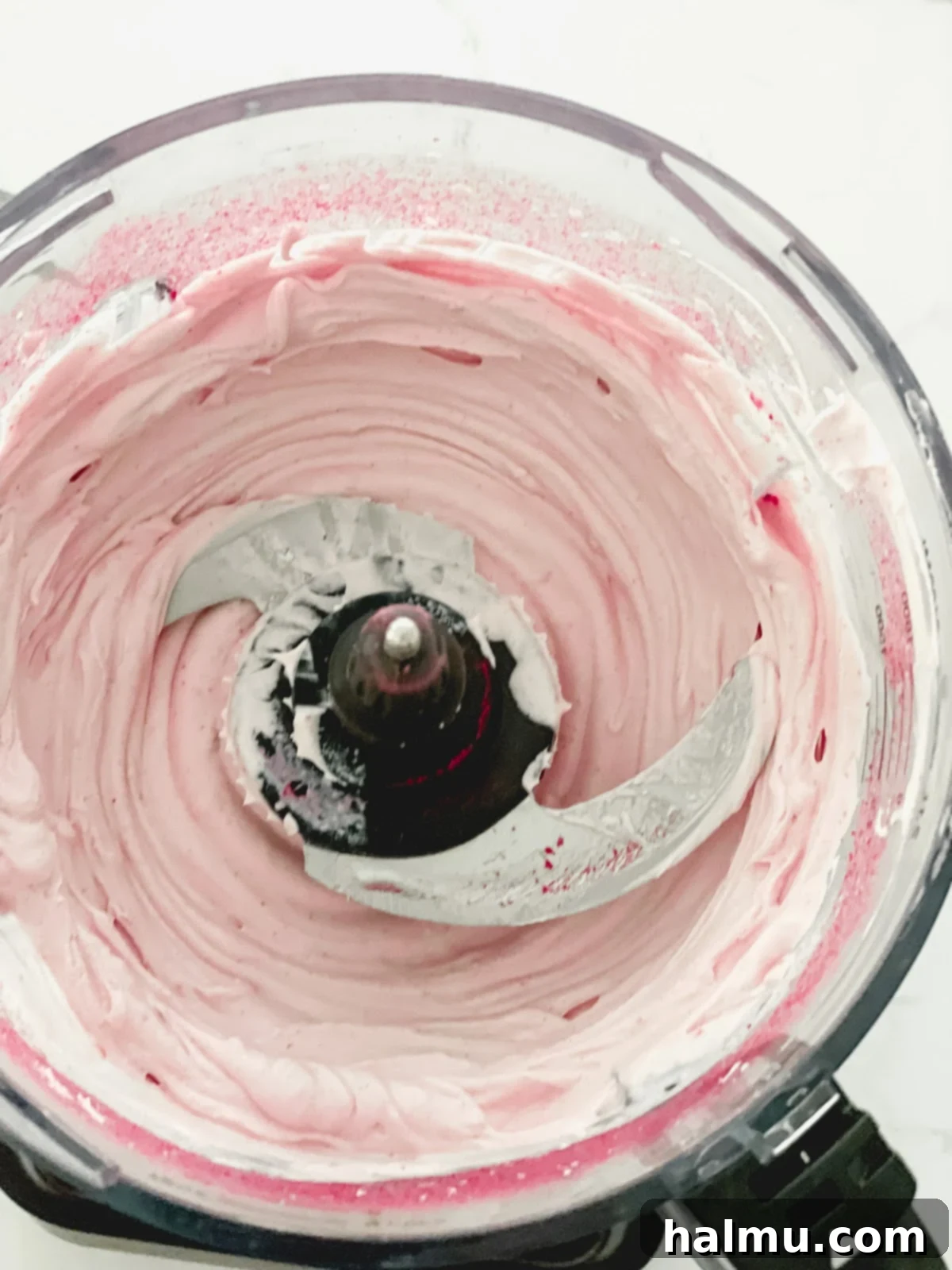 Bowl of freshly made raspberry whipped cream, ready for cake assembly.