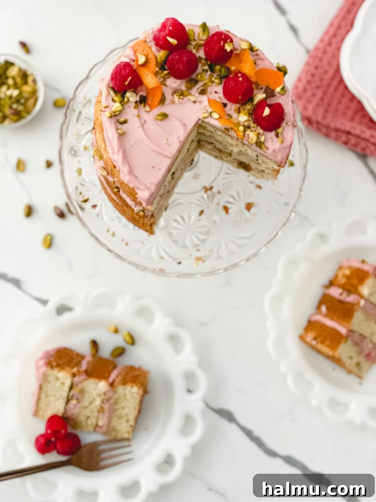 A fully assembled Raspberry Orange Pistachio Cake, ready to be sliced.