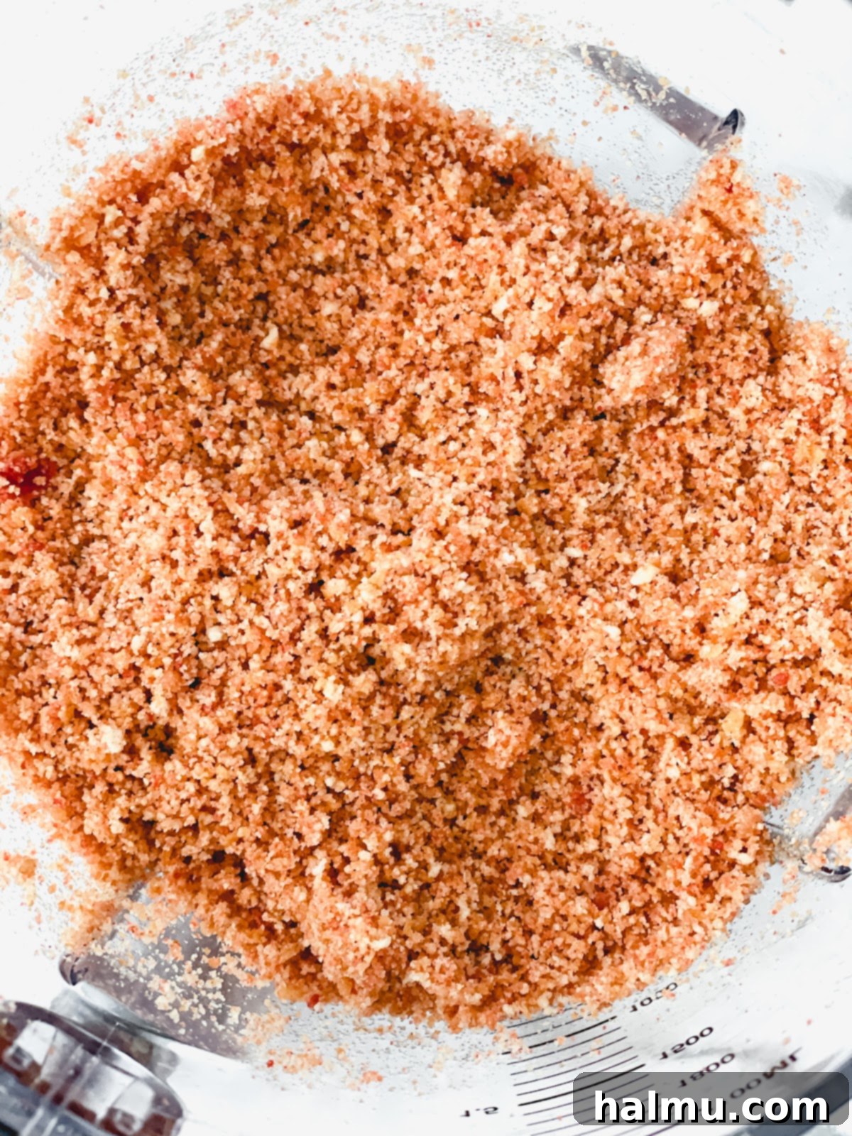 Pressing the Nilla wafer and strawberry crumble into a springform pan.