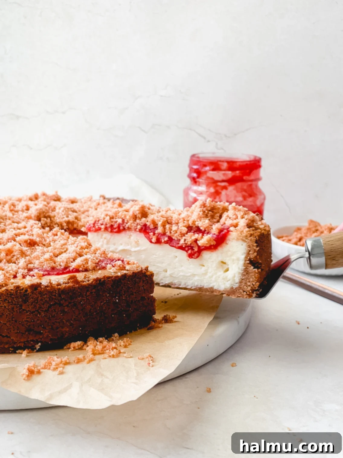 Close-up of a slice of Strawberry Crunch Cheesecake on a plate.