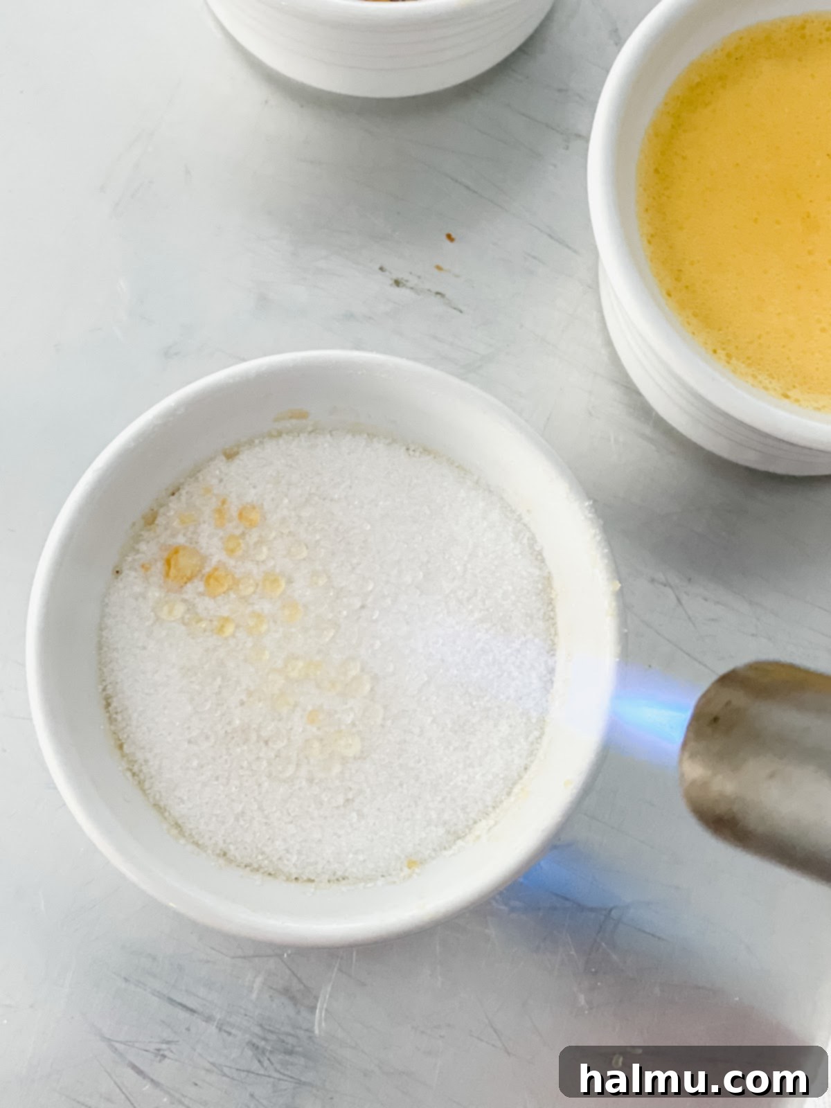 Rich Vanilla Bean Creme Brulee 7 A kitchen torch caramelizing the sugar on top of a Crème Brûlée.