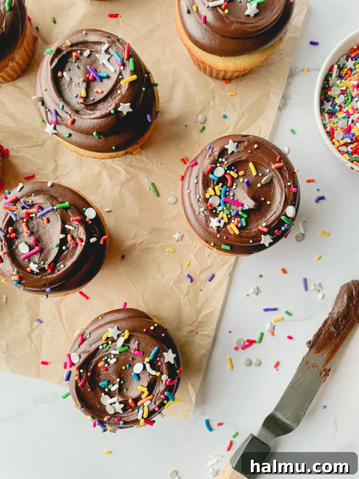 Close-up of freshly baked vanilla bean cupcakes in liners, cooling on a wire rack