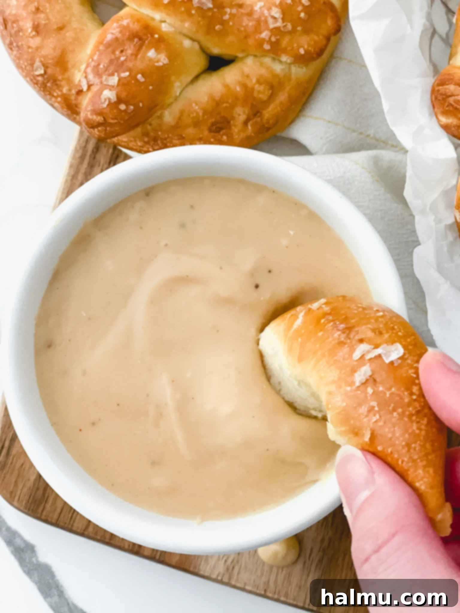 Delicious Warm Beer Cheese Dip served in a small bowl with soft pretzels