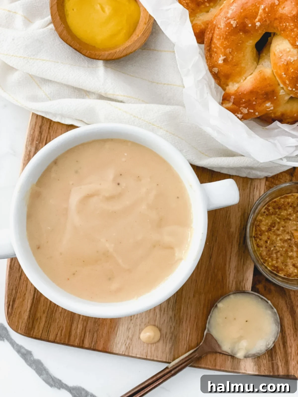 Ingredients for Warm Beer Cheese Dip laid out on a wooden board