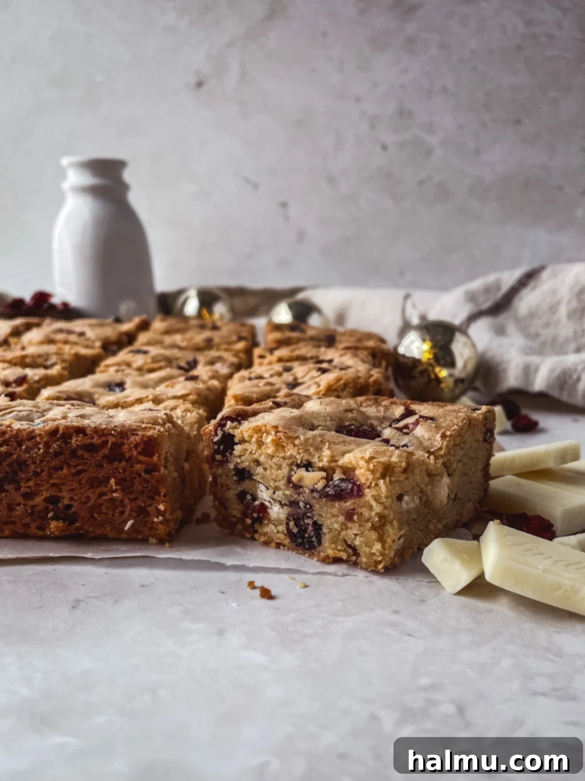 A stack of perfectly baked White Chocolate Cranberry Blondies resting on a wire cooling rack.