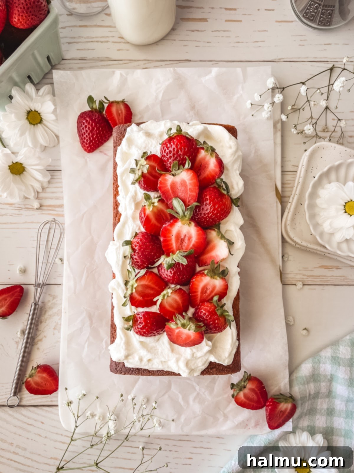 Yuzu Strawberry Pound Cake topped with whipped cream and sliced strawberries