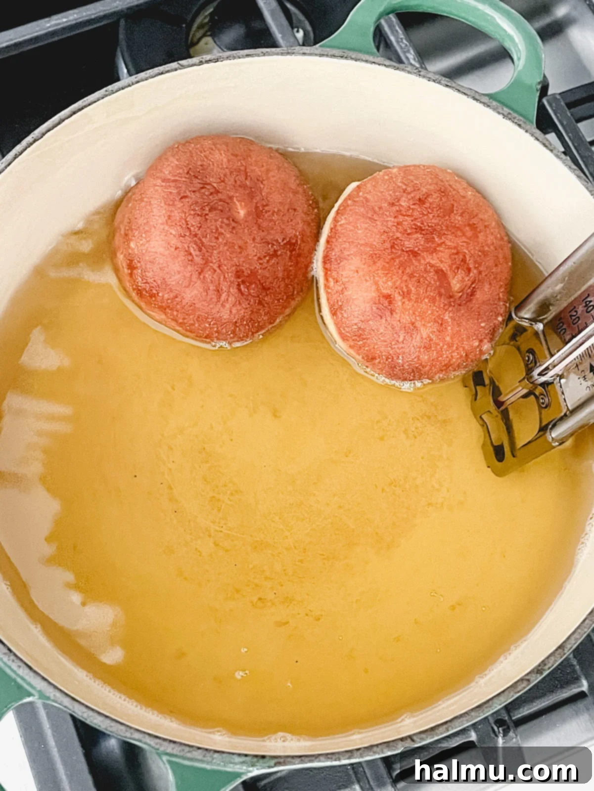 Decadent Chocolate Custard Brioche Donuts 5 Freshly fried, golden-brown brioche donuts, coated in sugar, on a cooling rack.