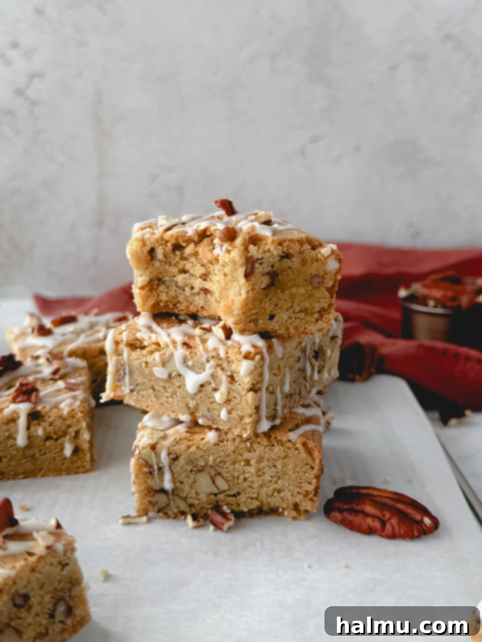 Artfully arranged Maple Pecan Blondies on a rustic wooden board, garnished with whole pecans and a light dusting of powdered sugar, ready to be served.