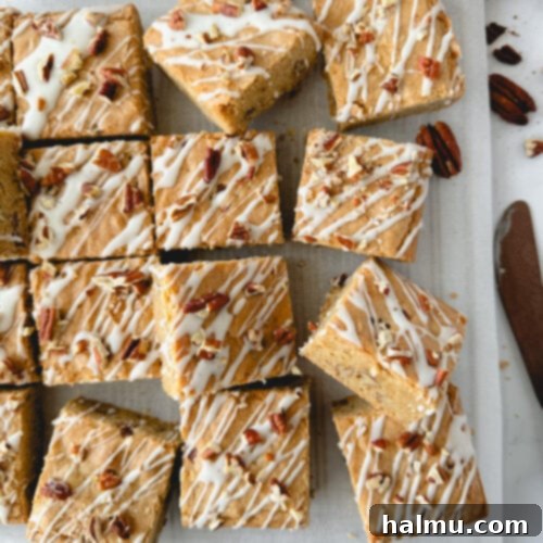 A perfectly baked Maple Pecan Blondie, drizzled with sweet maple glaze and sprinkled with toasted pecans, ready to be devoured.