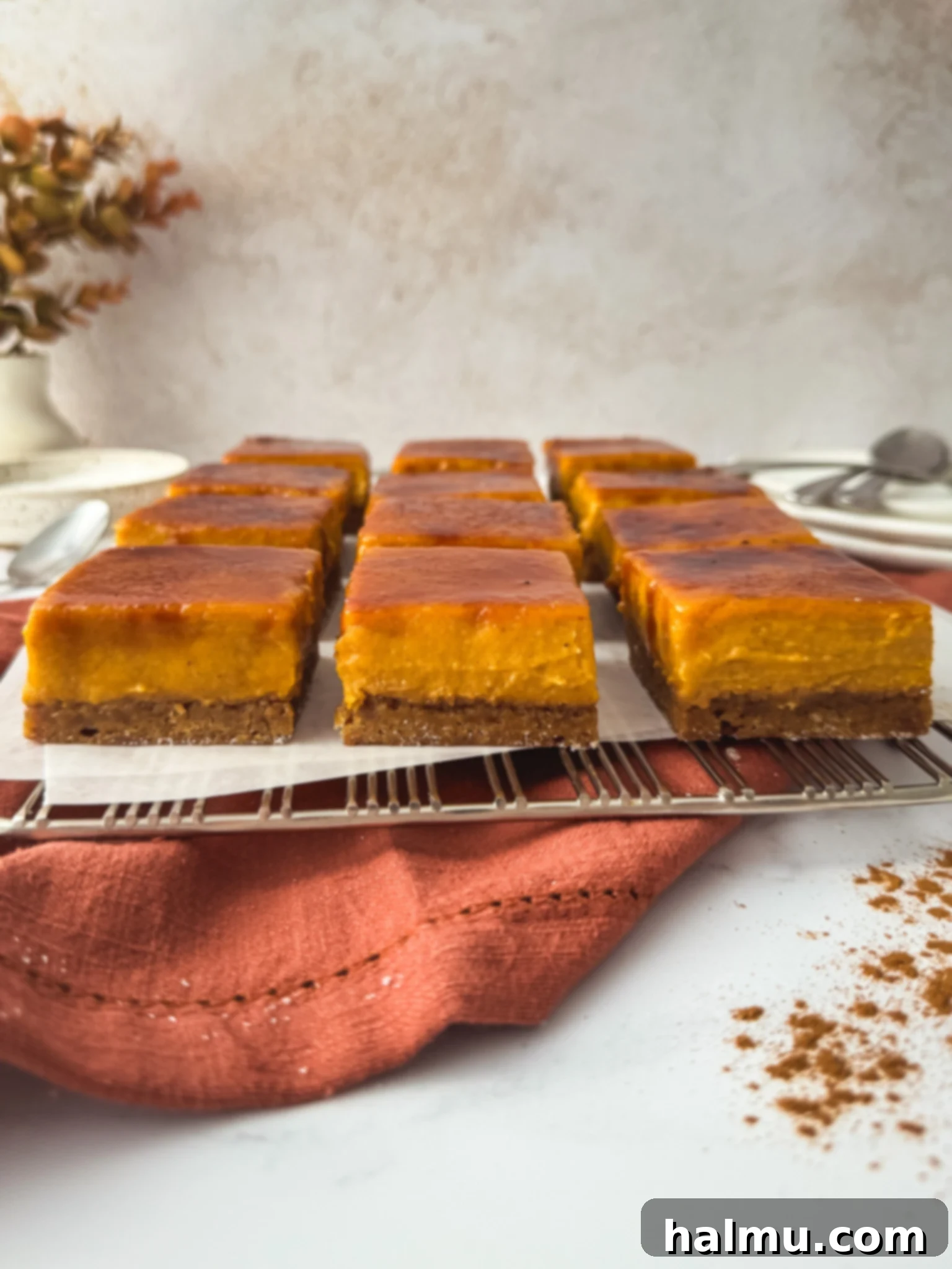 Close-up of a Pumpkin Spice Crème Brûlée Bar slice showing the distinct gingerbread base, pumpkin custard, and brûlée top.